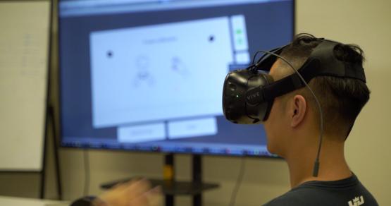 A student in China works with a virtual reality glove by Noitom.